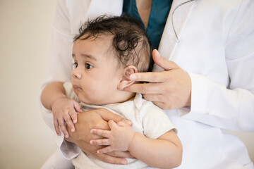 Close up of doctor checking baby's ear