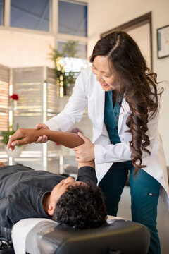 Woman doctor looking at patients arm