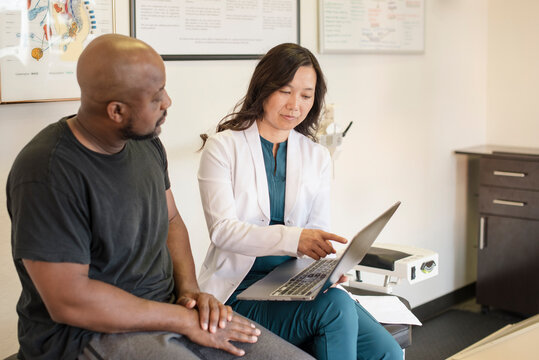 Doctor showing patient information on computer