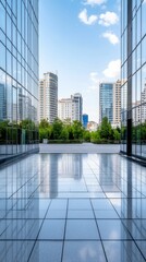 Obraz premium Modern city landscape showing glass buildings and greenery under a clear blue sky during daytime hours