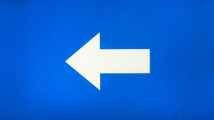white arrow on a blue background pointing to the left