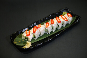 A selection of fresh sushi served on a plate, showcasing an assortment of rolls with vibrant colors and textures. The dish is perfect for an Asian restaurant menu, highlighting traditional flavors.