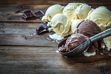 Delicious assortment of ice cream scoops with chocolate pieces on a wooden table