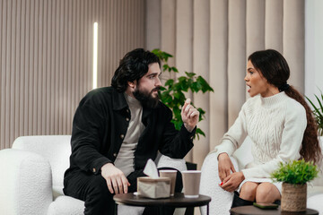 Multiethnic young couple on consultation with therapist. Black young woman discusses relationship problems. Unhappy caucasian man listens his girlfriend. Couples therapy