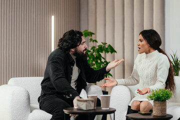 Nervous American man loses temper. Multiethnic couple having conflict during couples therapy with psychologist. African black woman argue with her husband. Psychological therapy, personal crisis