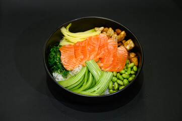 An Asian bowl with a vibrant mix of vegetables, meat or fish, served on a bed of rice in a sleek black bowl. The dish showcases a colorful and nutritious combination, perfect for a modern restaurant 