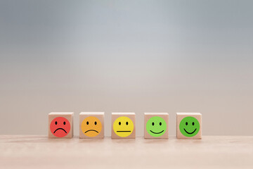 Customer evaluating service quality using emojis on wooden cubes