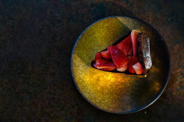 Chocolate Cake Slice with Fresh Strawberries on a Rustic Plate