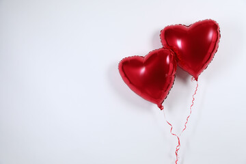 Heart-shaped red balloons on light background, space for text. Valentine's day © New Africa