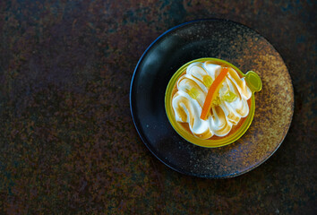 Orange meringue tart on a rustic plate.