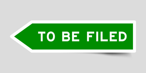 Green color arrow shape sticker label with word to be filed on gray background