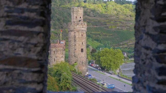 Ochsenturm or Bull Tower revealed through a medieval stone wall during an early sunny autumn morning, Oberwesel, Rhine Valley, Germany 
