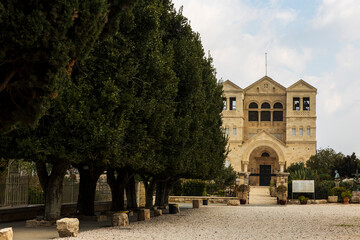 Obraz premium Mount Tabor, Israel – February 3, 2025: A long avenue of cypress trees leading to the Church of the Transfiguration grounds at the mountain summit.