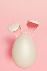 Easter egg with bunny ears on a pink background, symbolizing the festive spirit. 3d rendering