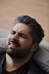 Obraz premium Handsome man enjoying a moment of contemplation in a cozy indoor setting