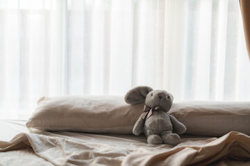Gray Rabbit Plush Toy on a Cozy Bed by the Window