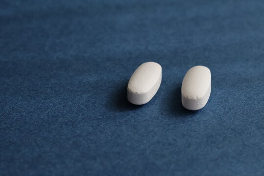 Una toma de varias pastillas de color blanco colocadas en un fondo azul 