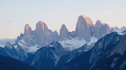 Obraz premium Majestic Mountain Peaks at Sunrise with Snow and Clouds in Sky