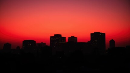 Vibrant Sunset Over City Skyline with Silhouette of Buildings