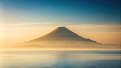 Serene Sunrise Over a Misty Volcanic Peak and Calm Ocean