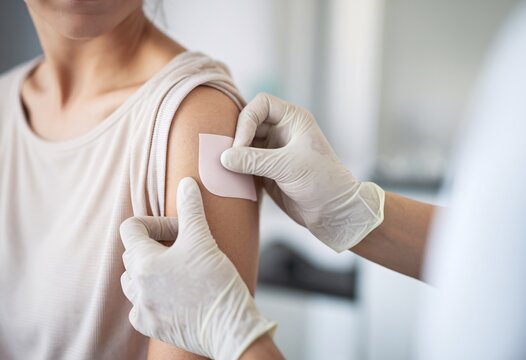 Woman receiving vaccination in a clinical setting during daytime - Powered by Adobe