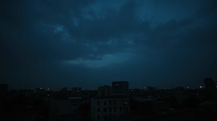 Dark Cloudy Sky Over City Skyline at Dusk with Faint Lights