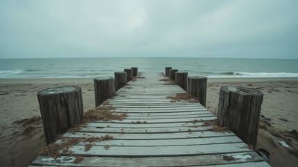 Fototapeta premium Tranquil Wooden Pier Leading to Calm Ocean Under Overcast Sky