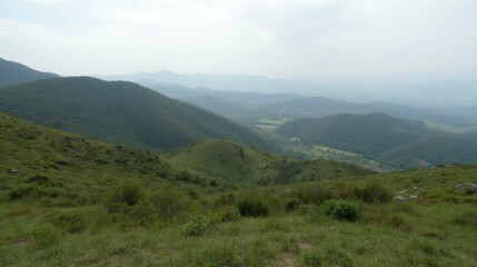 Obraz premium Serene Mountain Landscape with Lush Green Valleys and Misty Horizon
