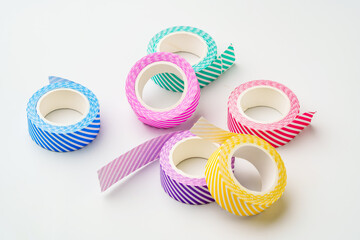 Colorful striped washi tape rolls arranged on a clean surface for craft and DIY projects