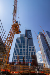Construction site in downtown San Francisco with a crane and skyscrapers, capturing the city's modern architecture, urban development, and progress under a clear blue sky.
