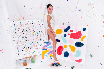 Female artist in her art studio with colorful paintings