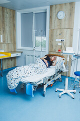 A young woman has almost given birth to a baby. A woman in labor. A delivery room in a maternity hospital.