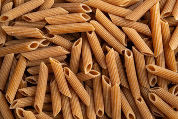 Organic whole wheat pasta,durum semolina flour macaroni,uncooked Penne rigate for background.