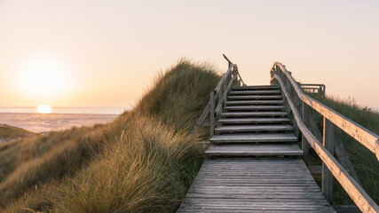 Sonnenuntergang mit Düne und Aussichtspunkt am Nordseestrand