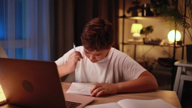 Cute little boy studying with lack of new ideas or creative block writing and crossed out at home Worried kid with failed ideas studying at late night