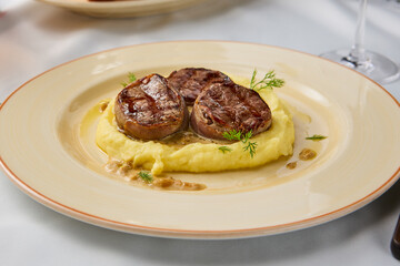 Gourmet Veal Medallions with Creamy Mashed Potatoes in Elegant Dining Setting
