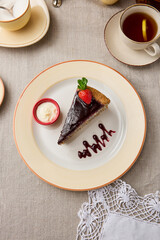 Elegant Chocolate Poppy Seed Cake Slice on Rustic Table Setting with Tea
