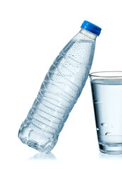 Full small plastic water bottle with drops leaned on a full water glass, close up, studio shot