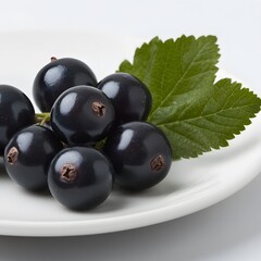 Juicy blackcurrants on plate, leaves, white background, food photography