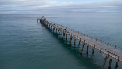 Fototapeta premium Empty Pier Deck Over the Calm and Peaceful Flat Waters of the Atlantic Ocean in Deerfield Beach Florida