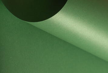 Glossy green paper background with a smooth, shimmering surface, elegant and modern texture featuring subtle curves and gradients, perfect for decorative and designer applications.