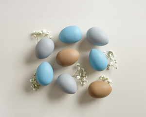 Elegant Easter Composition with Pastel Eggs and Spring Blossoms, still life Dyed eggs in soft pastel colors, top view spring holiday minimal creative pattern, neutral earth colored image, above