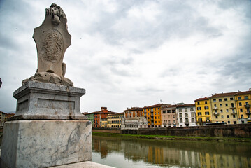 View on Arno river and colorful building, reflection in water, Pisa, Italy