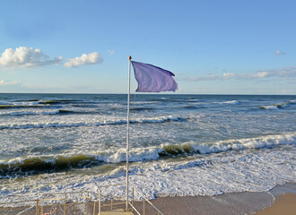 Warning purple beach flag with the Baltic Sea in the background