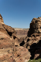 Fototapeta premium Rugged red cliffs and vast sandy expanses create a mesmerizing desert scene. 