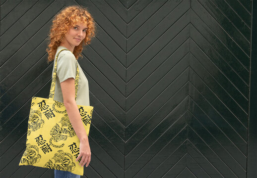 Woman Holding a Tote Bag in Front of a Textured Wall