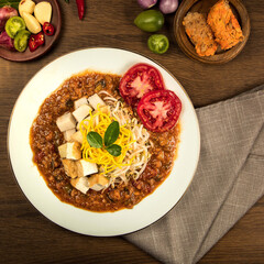 Indonesian traditional ketoprak, A vibrant traditional dish features shredded meat, pasta, and fresh vegetables garnished beautifully, highlighting rich flavors and textures