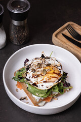 White plate of waffles and salmon with egg and seeds angle view
