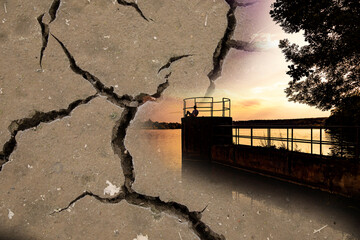 Dry ground as background with sunset and silhouette of person by lake.