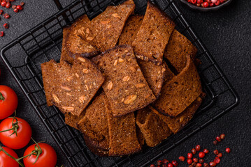Crispy homemade brown bread chips with seeds and grains, salt, spices
